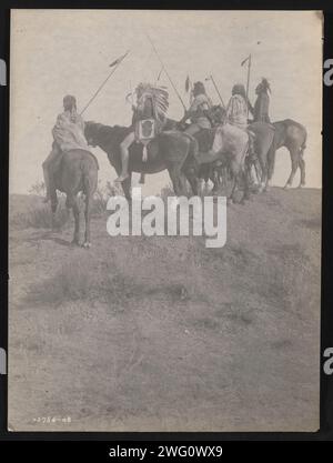 Affacciato sul Little Horn, 1908. La fotografia mostra cinque Crow Indiani, Wolf, spettacoli di pesci (con copricapo), in che direzione, Lone Tree e due fischi sul personale di trasporto a cavallo. Foto Stock