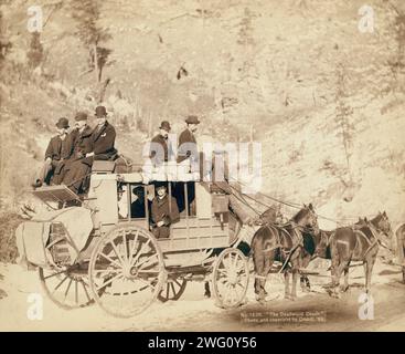 Il Deadwood Coach, 1889. Vista laterale di una diligenza; uomini vestiti formalmente seduti sul pullman e sopra di esso. Foto Stock