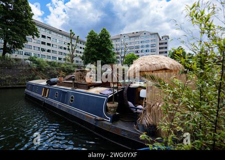 Londra - 29 05 2022: Molo di Lisson Grove con casa galleggiante ormeggiata, con patio in bambù e ombrellone. Foto Stock