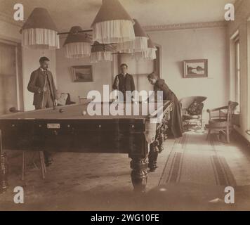 Frederick S Pray, David M Clarkson, e Sarah e Smith, posate dal tavolo da biliardo, Dom Smith, Vladivostok, Russia, 1899. Mostrando l'occupazione del tempo libero descritta da Eleanor Pray in una lettera datata 21 gennaio 1898: "Mr. Clarkson è venuto ieri sera a giocare a biliardo e hanno giocato fino alle dieci e mezza. È molto bello avere il tavolo da biliardo, perché ora, se i signori si fanno avanti per passare la serata, possiamo metterli in fila nella sala da biliardo e io e Sarah possiamo leggere o cucire, o fare quello che vogliamo." In: Album fotografico di pregare la famiglia espatriata vita a Vladivostok, Russia. Eleanor L. Pra Foto Stock