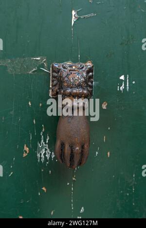 Mano come una porta bussa su una porta d'ingresso nel centro storico di Genova, Italia Foto Stock