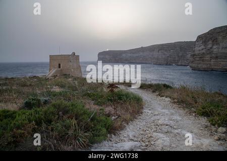 Una splendida foto dello splendido paesaggio roccioso che circonda la baia di Xlendi a Malta Foto Stock