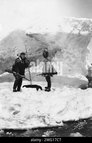 Eskimo con un altro uomo nella scena invernale, tra c1900 e 1927. Foto Stock