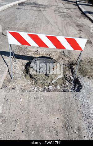 riparazione e installazione del tombino stradale Foto Stock