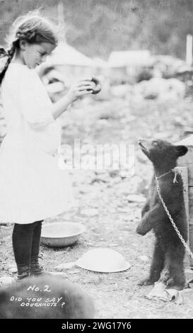 Ragazza e cucciolo d'orso, tra c1900 e 1916. Foto Stock