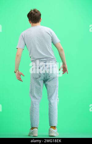 Un uomo, a tutto tondo, su sfondo verde Foto Stock