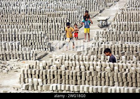 I lavoratori lavorano in un brickyard il 2 febbraio 2024 a Dacca, Bangladesh. Il Bangladesh attraversa una rapida urbanizzazione. La rapida urbanizzazione genera una domanda massiccia di mattoni, in quanto è uno degli ingredienti chiave per costruire strutture in cemento. Per rispondere a questa crescente esigenza, il numero dei campi di produzione di mattoni è aumentato a un ritmo allarmante in Bangladesh. La maggior parte di essi avviene in terreni agricoli che causano una riduzione della produzione agricola, e la combustione del carbone provoca enormi emissioni di CO2 di carbonio-di-ossido, che è principalmente responsabile del cambiamento climatico. Dhaka Dhaka Distretto di Bangla Foto Stock