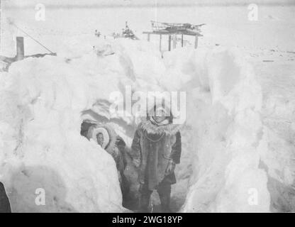 Alaskan Eskimos con la loro casa invernale metà sotterranea nel villaggio di Stebbins, tra c1900 e c1930. Foto Stock