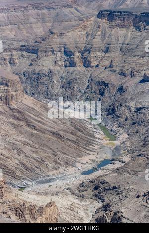 Paesaggio aereo con poca acqua nel fiume Fish e pendii ripidi della scarpata, fotografato con la luce di tarda primavera dal punto panoramico del Canyon a Fish River CA Foto Stock