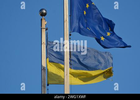 La bandiera nazionale dell'Ucraina e la bandiera dell'Unione europea sbattono sullo sfondo del cielo di Kiev. Il 1° febbraio 2024, l'Unione europea, con un numero di 27 paesi, ha votato all'unanimità un pacchetto di aiuti a favore dell'Ucraina per un importo di 50 miliardi di euro nel quadro del bilancio dell'Unione europea. L'Ucraina continua a resistere all'aggressione militare della Russia Foto Stock