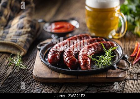 Salsicce fritte con spezie salsa barbecue birra alla spina ed erbe - primo piano. Foto Stock