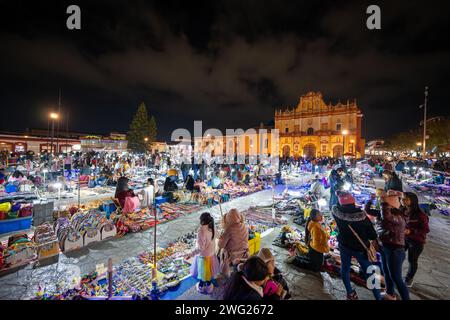 La strada affollata del mercato di notte con Catedral de San Cristobal de las Casas sullo sfondo Foto Stock