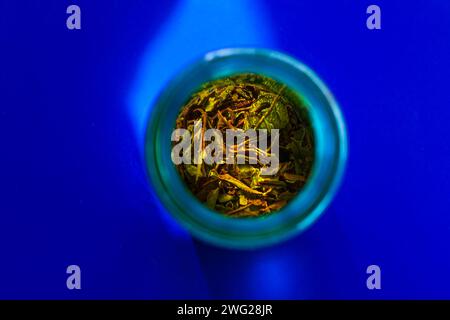 Preparare il tè verde freddo in una bottiglia riutilizzabile turchese su sfondo blu pastello. Rinfrescante mockup con marchio di bevande analcoliche ghiacciate. Dieta sana. Zero wa Foto Stock