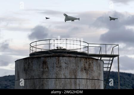 Un gruppo di droni militari che attaccano il serbatoio del combustibile e del petrolio, rendering 3d. Foto Stock