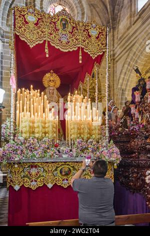 Jerez de la Frontera, Spagna - 2 febbraio 2024: Uomo con grande devozione davanti ad un pass della settimana Santa che scatta una fotografia della Vergine con il suo cellulare Foto Stock