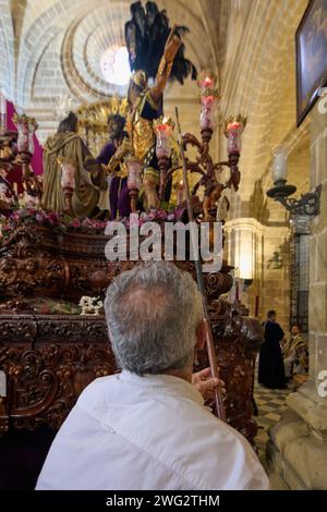 Jerez de la Frontera, Spagna - 2 febbraio 2024: Jerez de la Frontera, Spagna - 2 febbraio 2024: Uomo irriconoscibile che accende le candele di una settimana Santa Foto Stock