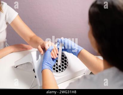 Un manicurista che deposita le unghie di un cliente in un salone di bellezza. Cura delle unghie. Foto Stock