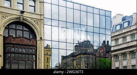 Edifici dal paesaggio urbano che si riflettono in un'elegante facciata in vetro Foto Stock