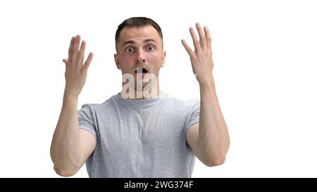 Un uomo con una maglietta grigia, su sfondo bianco, primo piano, deluso Foto Stock