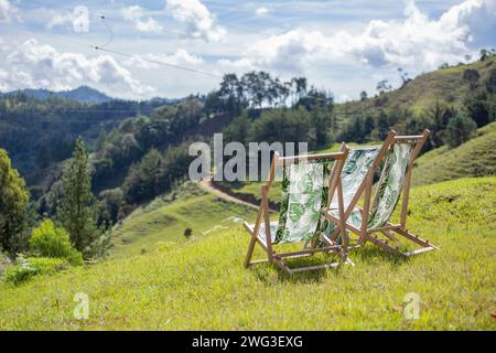 Sedie in legno, con tessuti vegetali, nelle verdi montagne. Foto Stock