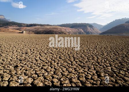 Vilanova De Sau, Spagna. 2 febbraio 2024. Il terreno bruciato e asciutto è visibile nel serbatoio dell'acqua di Sau. Le autorità della Catalogna hanno dichiarato lo stato di emergenza giovedì 01 febbraio dopo che i livelli dei serbatoi idrici della regione sono scesi al di sotto del 16% della capacità totale. Saranno imposte misure per limitare l'utilizzo dell'acqua sia delle infrastrutture pubbliche che delle imprese private, con ripercussioni sulla vita di oltre 6 milioni di persone. Si dice che il cambiamento climatico sia una delle cause principali della siccità in varie regioni della Spagna e nella regione mediterranea. Credito: SOPA Images Limited/Alamy Live News Foto Stock