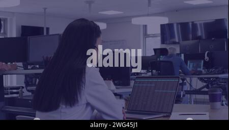 La giovane donna birazziale lavora diligentemente alla scrivania del suo ufficio Foto Stock