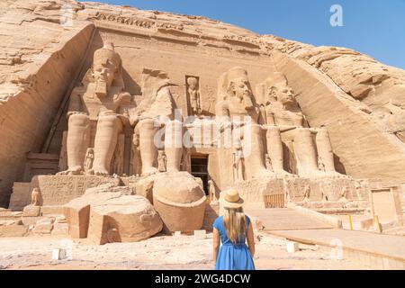 Abu Simbel, Egitto - Una donna dai capelli biondi con un cappello si trova di fronte al tempio di Abu Simbel in Egitto, Foto Stock