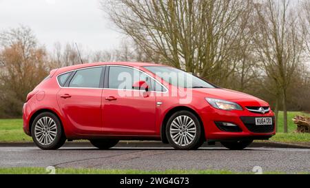 Milton Keynes, UK- 2 febbraio 2024: 2014 auto Vauxhall Astra rossa che guida su una strada di campagna inglese. Foto Stock