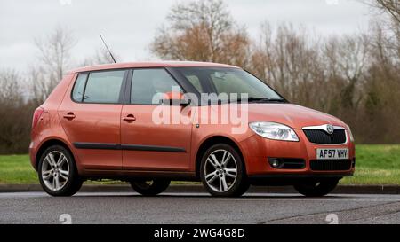 Milton Keynes, Regno Unito - 18 gennaio 2024: 2007 auto Skoda Fabia arancione che guida su una strada di campagna inglese. Foto Stock