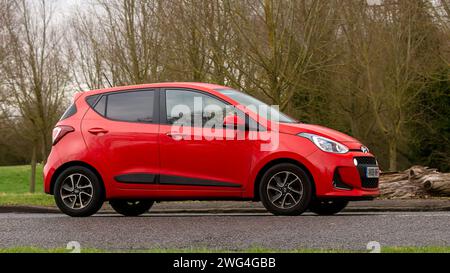 Milton Keynes, Regno Unito - 2 febbraio 2024: 2018 auto Hyundai i10 rossa che guida su una strada di campagna inglese. Foto Stock