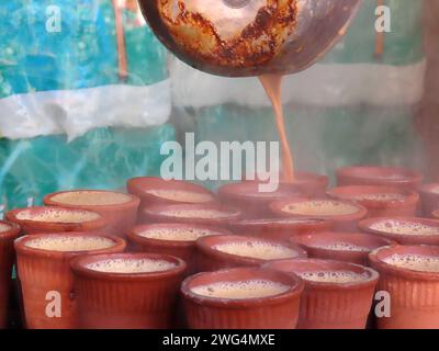 Autentico Street drink locale e tradizionale in India e nell'Asia meridionale, tè speziato o non speziato di Chai. Liquido versato da una pentola dopo l'uso Foto Stock
