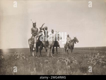 Il partito della guerra, 1905. La fotografia mostra un gruppo di Crow Indiani a cavallo. Capo, in mezzo, con il copricapo. Foto Stock