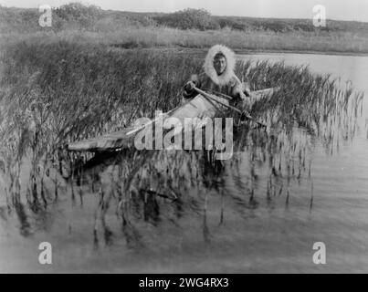 Il Muskrat-Hunter-Kotzebue, c1929. Kotzebue Man pagaia in kayak attraverso palude. Foto Stock