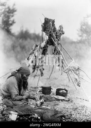 Una cucina farsi, c1927. Sarsi donna che cucina sul fuoco, Alberta, Canada. Foto Stock