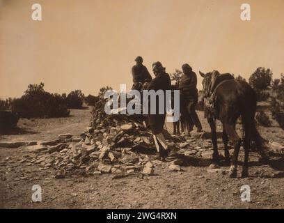 Al santuario Navaho, c1904. Tre Navajos con cavalli, raccolti davanti a un tumulo di rocce e vegetazione. Foto Stock
