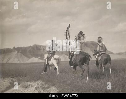 Un partito di guerra Sioux, 1905. La fotografia mostra tre guerrieri, che indossano il copricapo, cavalcano a cavallo, uno con una lancia piumata e gli altri con fucili. Foto Stock