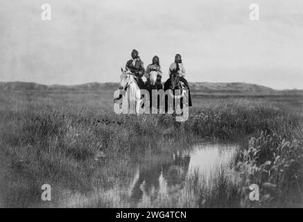 Nella terra dei Sioux, c1905. Tre indiani Sioux a cavallo di fronte allo stagno sulle pianure. Foto Stock