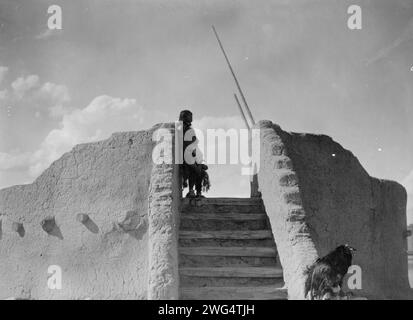 Guardia indiana Tewa in cima alle scale della kiva, San Ildefonso, New Mexico, c1905. Foto Stock