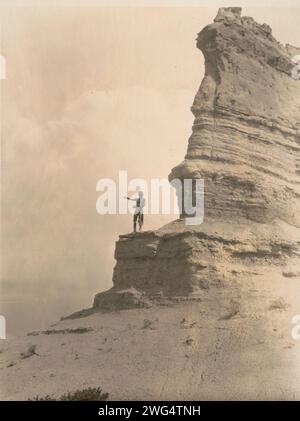 L'offerta-San Ildefonso, c1927. La fotografia mostra un uomo Tewa barechested, in piedi su una scogliera, braccia strette davanti a lui mentre spruzza farina di mais come offerta all'inizio di una giornata, al sole o a qualche altra divinità, o a eventi quotidiani mondani. Foto Stock