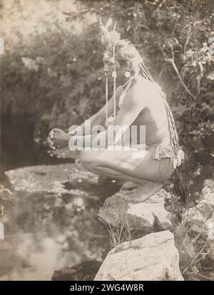 Sogni di un giorno, 1905. La fotografia mostra i colpi di stato di Chief Plenty che si accoccolano sulla roccia vicino allo stagno, le dita intrecciate, mentre meditano. Foto Stock