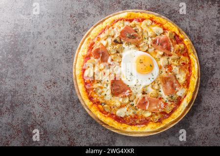 Pizza alla Bismarck un impasto base della pizza è condito con salsa di pomodoro, mozzarella, funghi, prosciutto e primo piano d'uovo sulla tavola di legno sulla linguetta Foto Stock