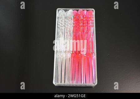 Bastoncini in plastica trasparente e rossa per piccoli sandwich e canapè in imballaggi in plastica. Foto Stock