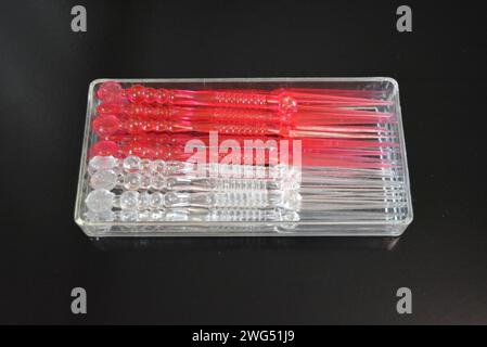 Bastoncini in plastica trasparente e rossa per piccoli sandwich e canapè in imballaggi in plastica. Foto Stock