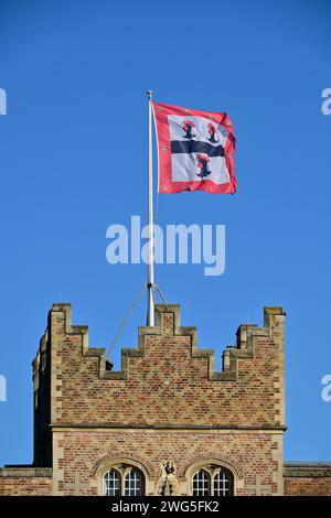 La torre della casa di guardia con la bandiera dello stemma del college, Jesus College vista da Jesus Lane, Cambridge, Inghilterra, Regno Unito. Foto Stock