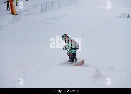 Trucchi per la scatola dello Snow Park. Snowboarder nel parco su una scatola. Jibbing invernale in snwopark nelle dolomiti. Foto Stock