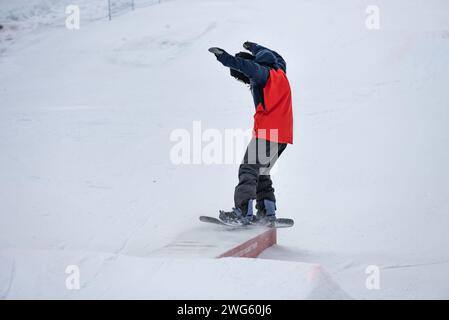 Trucchi per la scatola dello Snow Park. Snowboarder nel parco su una scatola. Jibbing invernale in snwopark nelle dolomiti. Foto Stock