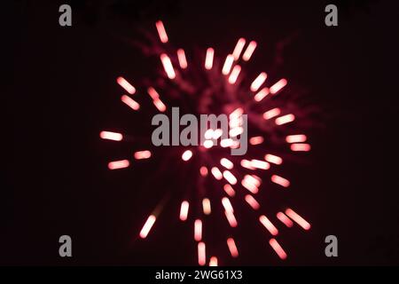 Raffica di rosso sfocato fuochi d'artificio fuori fuoco di notte - vivaci strisce e scintille - nuvole di fumo - festeggiamenti, Capodanno, 4 luglio, canada Foto Stock