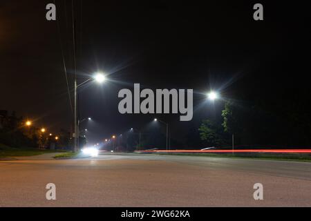 Il paesaggio urbano notturno - luci luminose - sentieri di luce rossa e bianca attraversano la strada - oltrepassando veicoli esposti a lungo. Preso a Toronto, Cana Foto Stock