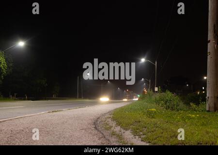 Il paesaggio urbano notturno - luci luminose - sentieri di luce rossa e bianca attraversano la strada - oltrepassando veicoli esposti a lungo. Preso a Toronto, Cana Foto Stock