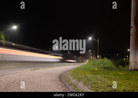 Il paesaggio urbano notturno - luci luminose - sentieri di luce rossa e bianca attraversano la strada - oltrepassando veicoli esposti a lungo. Preso a Toronto, Cana Foto Stock